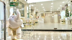 A hotel lobby with a reception desk, a large elephant statue, and a Christmas tree. - Abcyq Hotel Bangkok (Bangkok)