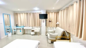 A hotel room with two beds, a desk, a chair, a TV, and curtains. - Abcyq Hotel Bangkok (Bangkok)