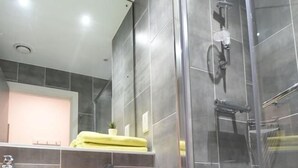 A modern bathroom with a toilet, sink, and glass-enclosed shower. - Yugo Lee Point (Cork)