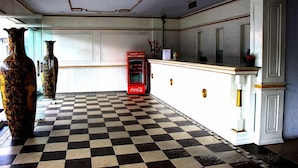 A checkered floor, a Coca-Cola vending machine, and two large vases. - Holiday Hotel Pekanbaru (Pekanbaru)