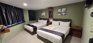 Habitación de hotel con dos camas, una mesita de noche, un espejo y una ventana con cortinas.