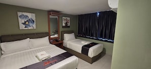 Habitación de hotel con dos camas, una mesita de noche, un espejo y una ventana con cortinas.
