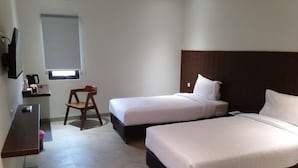 A hotel room with two beds, a desk, a chair, and a television. - Bell Hotel Merauke (Merauke)