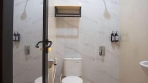 A modern bathroom with a toilet, bidet, and a mirror. - SH Hotel (Pangandaran)
