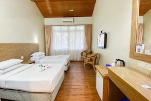 Habitación de hotel con dos camas, un escritorio, una silla, un televisor y un espejo.