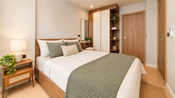 Ein Schlafzimmer mit Bett, Nachttisch, Lampe und einer Pflanze.