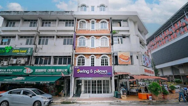 A hotel with a traditional facade, multiple windows, and a sign for 'Swing & Pillows'. - Swing And Pillows at ICC Pudu (Kuala Lumpur)