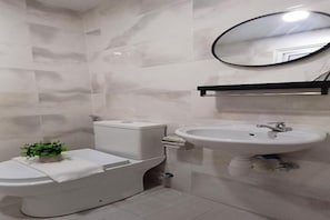 Un baño con inodoro, bidé y lavamanos.