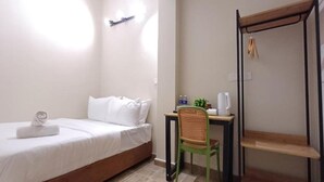 A single bed with white bedding, a small desk with a chair, a shelf, and a wall-mounted shelf. - Swing And Pillows at ICC Pudu (Kuala Lumpur)