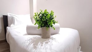 A bed with white bedding and a potted plant on it. - Swing And Pillows at ICC Pudu (Kuala Lumpur)