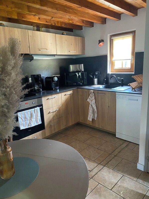 A kitchen with wooden cabinets, a microwave, a coffee maker, and a dishwasher.