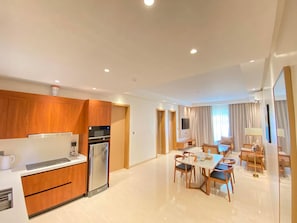 A modern hotel room with a kitchen, dining area, and a living space. - Cocotree Resort (Panglao)