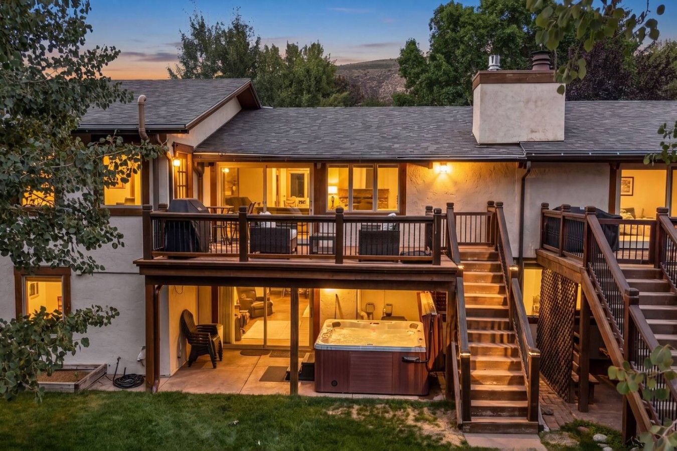 Una casa de dos pisos con un balcón, un jacuzzi y una escalera.