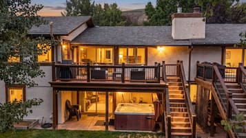 Una casa de dos pisos con un balcón, un jacuzzi y una escalera.