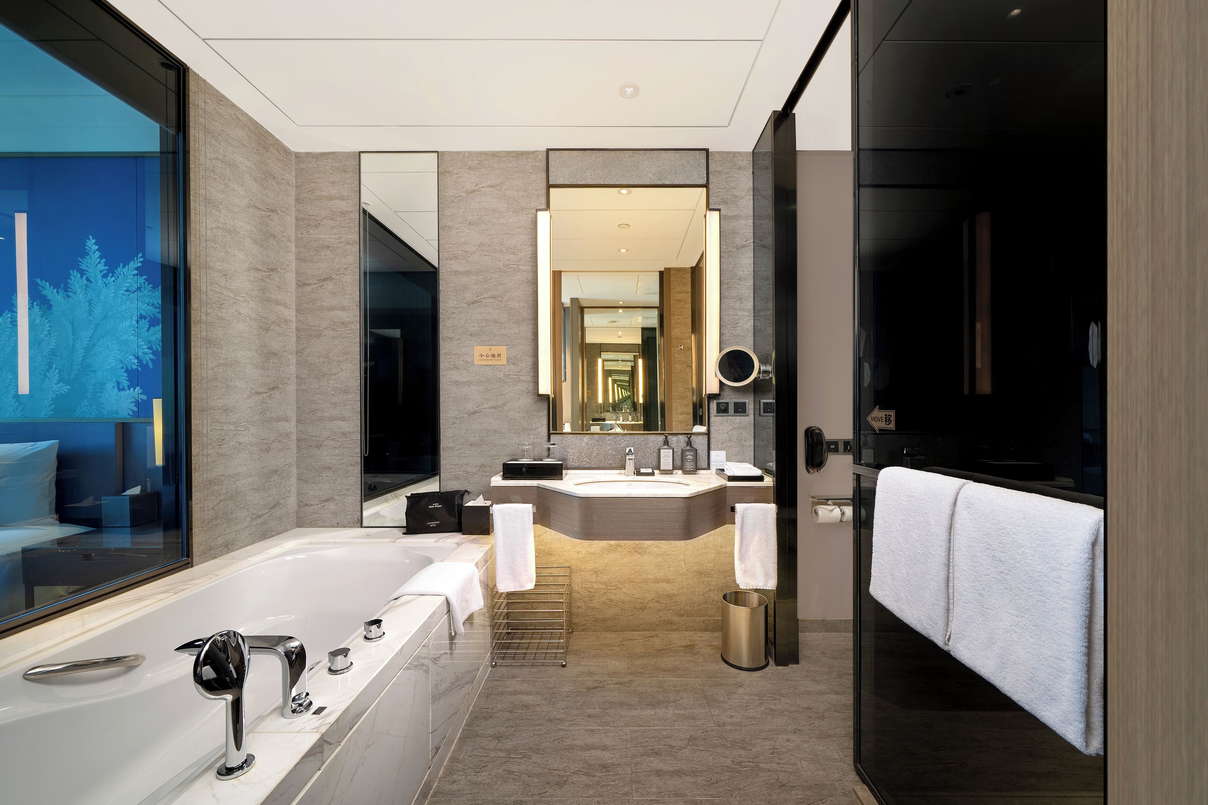 A modern bathroom with a large bathtub, a separate shower area, and a vanity with a mirror.