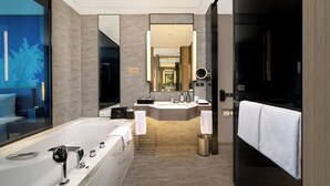 A modern bathroom with a large bathtub, a separate shower area, and a vanity with a mirror. - Steigenberger Harbin Sunac Land (Harbin)