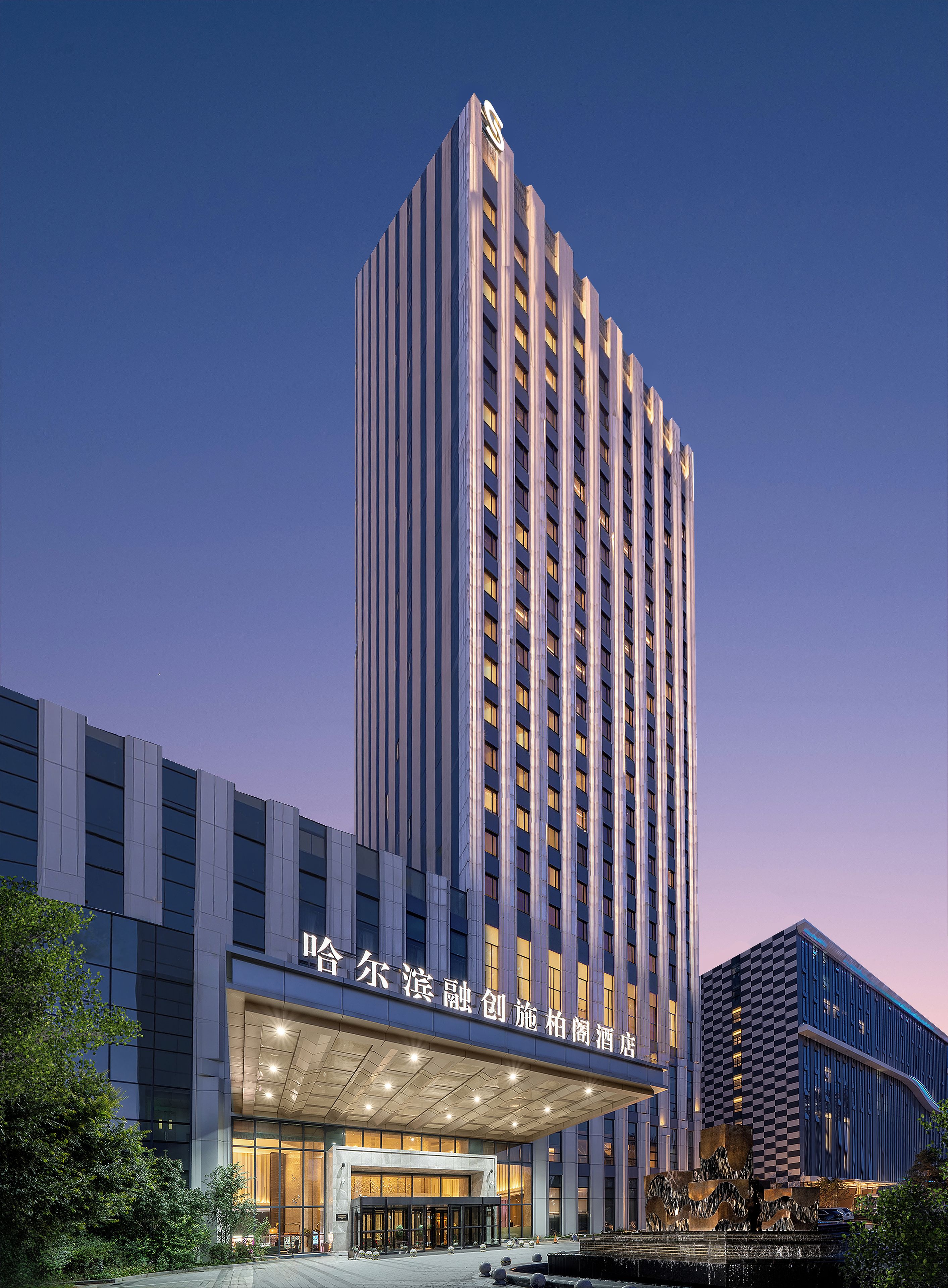 A high-rise hotel with a prominent entrance and a large, illuminated sign.