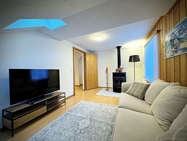 A living room with a television, sofa, and a fireplace.