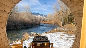 A wooden structure with a view of a river and mountains.