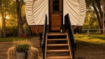 A covered outdoor structure with a wooden door and a set of stairs leading up to it.