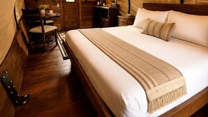 Una camera da letto accogliente, con soffitto a volta, un letto di legno, una sedia e un tavolino.