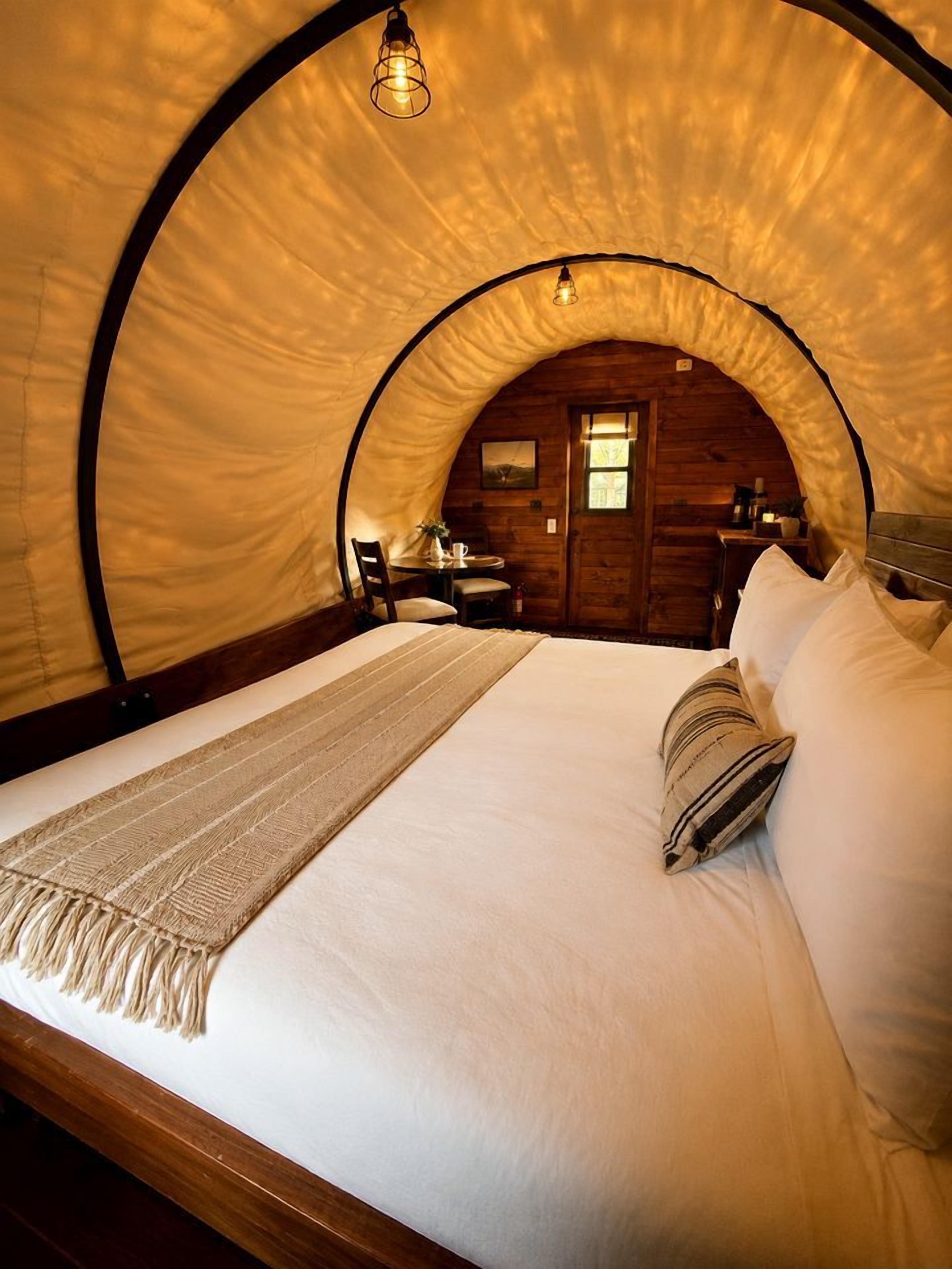 Una habitación circular acogedora con una cama, una mesa y una silla.