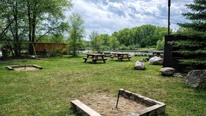 Un'area verde con tavoli da picnic e una piccola sabbiera.