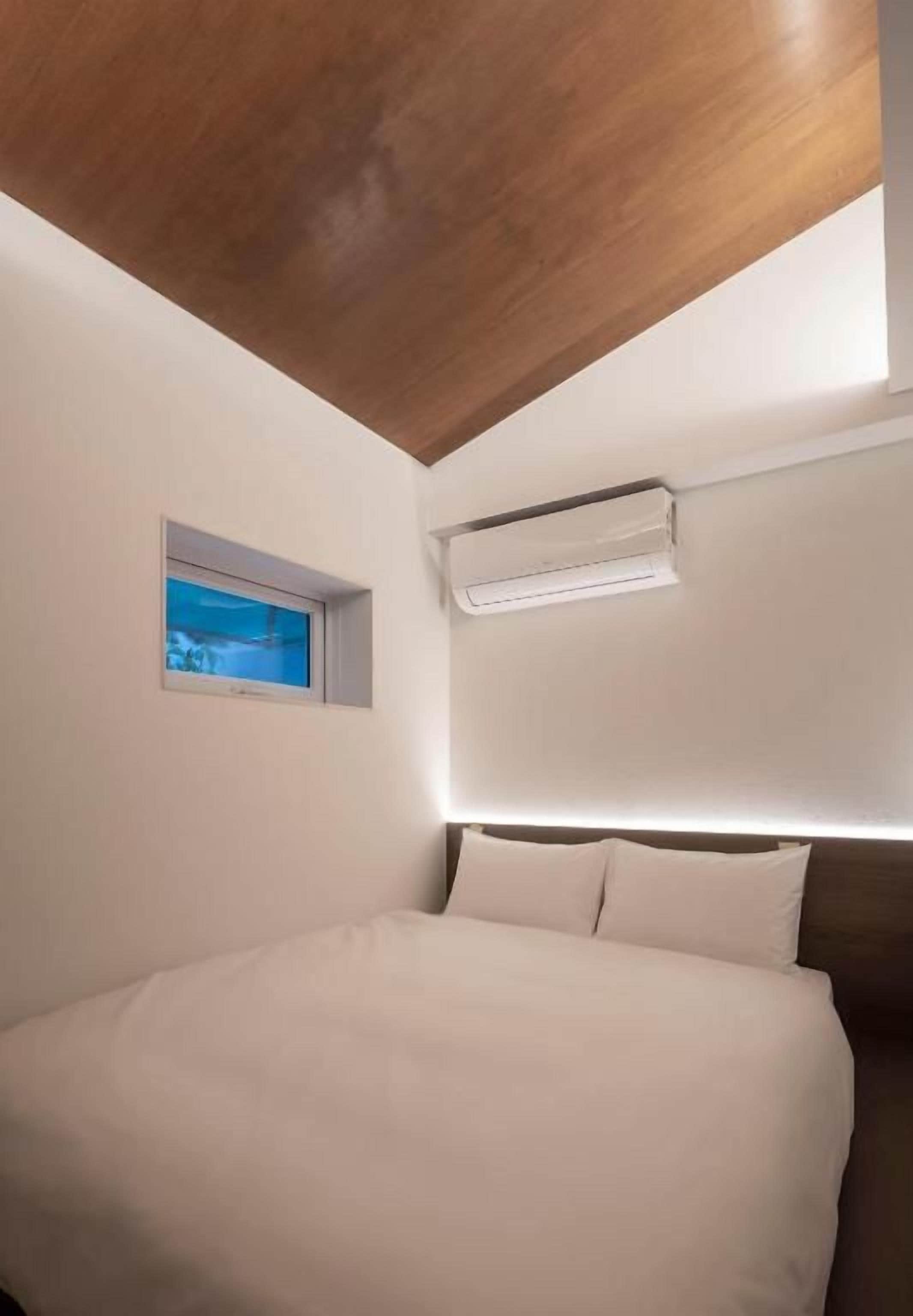 Ein Hotelzimmer mit Bett, Fenster und Klimaanlage.