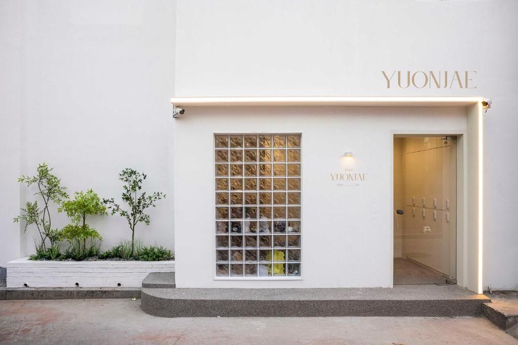 Un edificio con un letrero que dice 'YUONJAE' y una ventana con diseño de cuadrícula.
