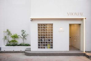 Un edificio con un letrero que dice 'YUONJAE' y una ventana con diseño de cuadrícula.