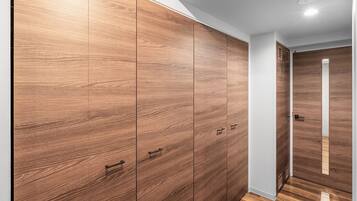 A hallway with wooden flooring and a large wardrobe with multiple doors.