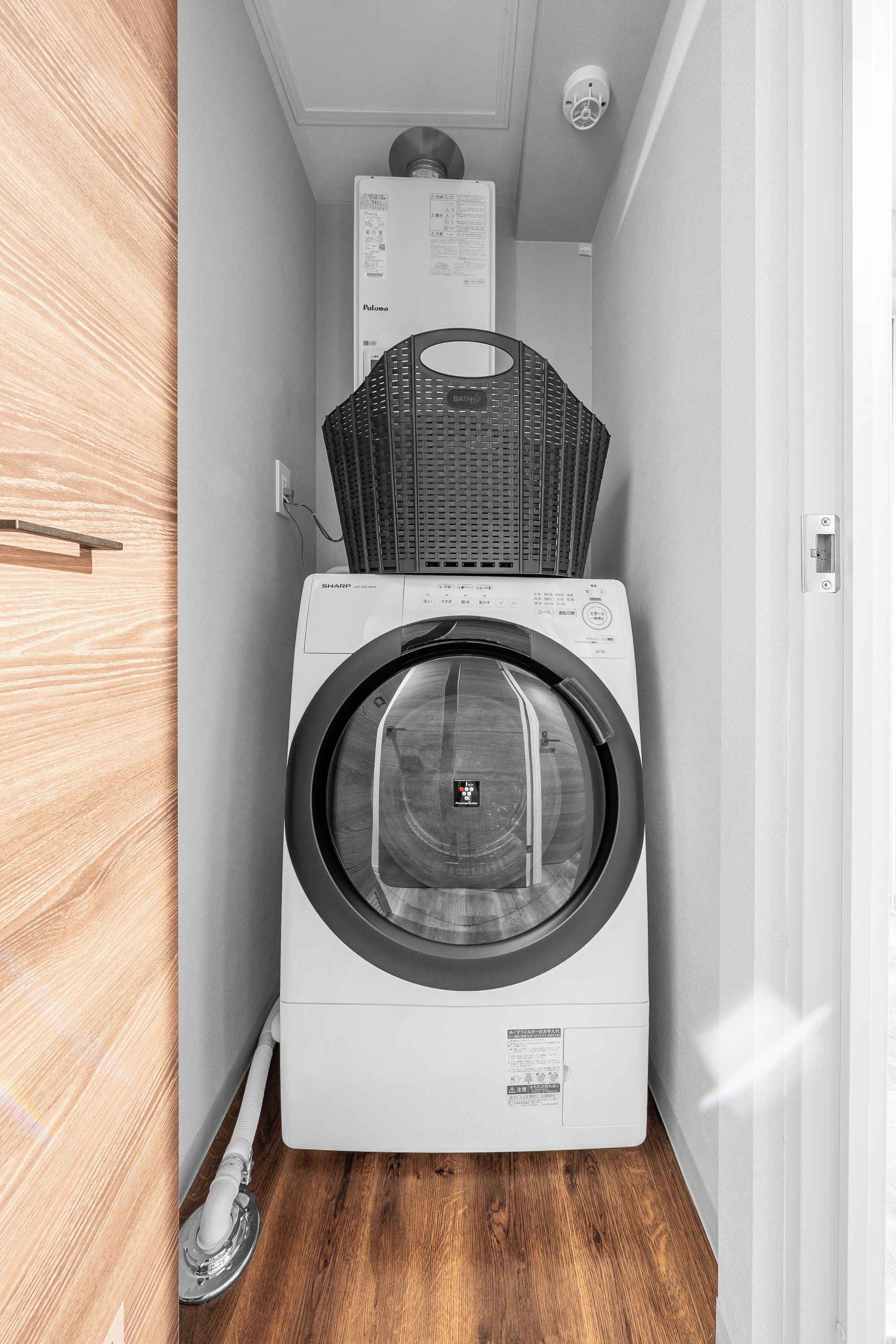A compact laundry room with a front-loading washing machine and a stacked dryer.