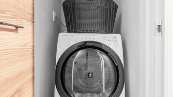 A compact laundry room with a front-loading washing machine and a stacked dryer.