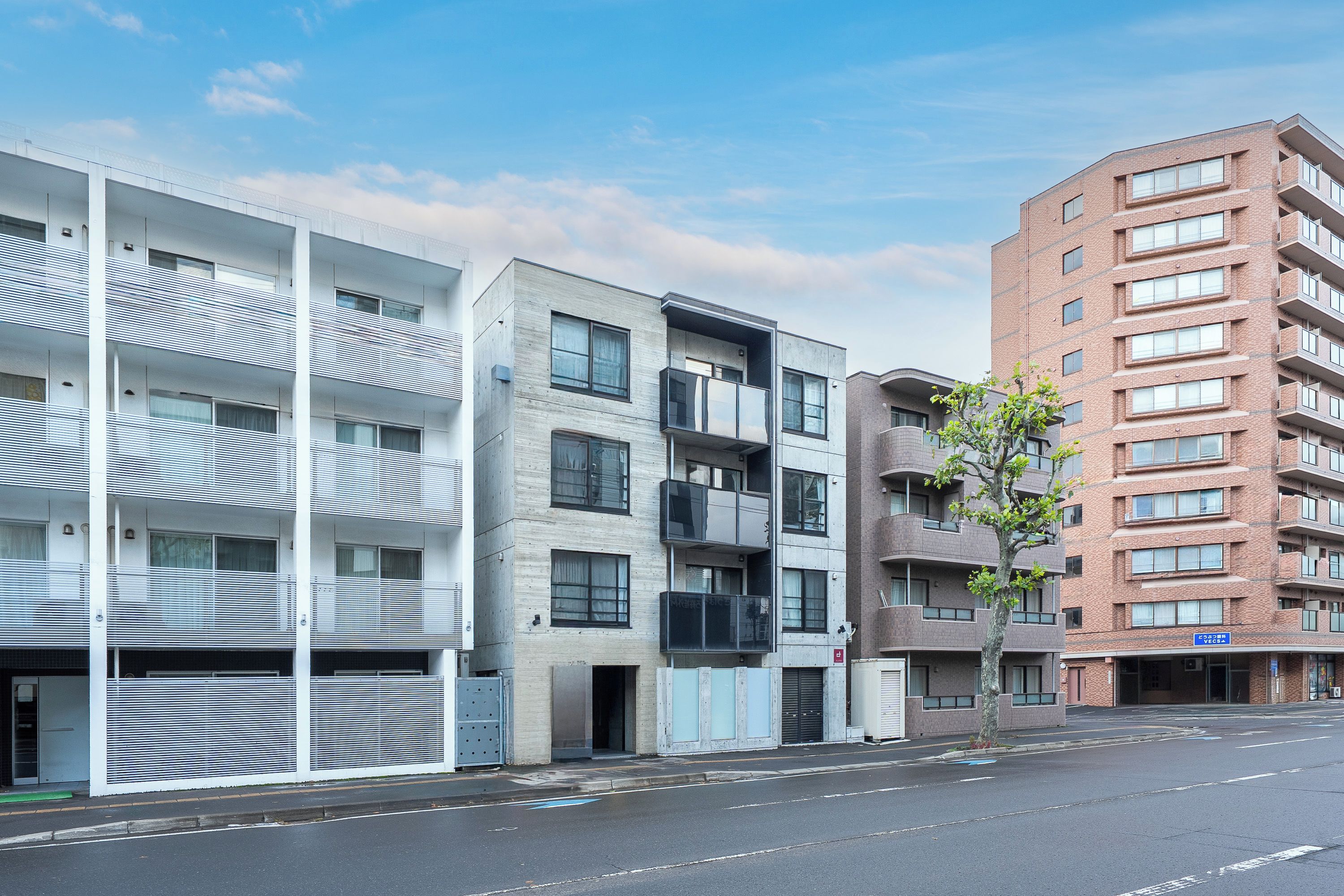 A multi-story building with balconies and a parking garage.