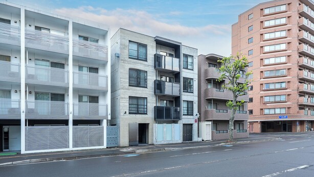 A multi-story building with balconies and a parking garage. - NOBLE 202 (Sapporo)