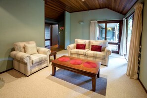 A living room with two sofas, a coffee table, and a wooden ceiling. - Gorgeous Country Cottage with a Fireplace near D'aguilar National Park, Queensland (Mount Glorious)
