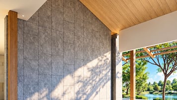 Un interior moderno con piscina, paredes de piedra y techo de madera.