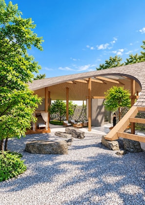 A covered outdoor seating area with stone seating and a wooden pergola structure.
