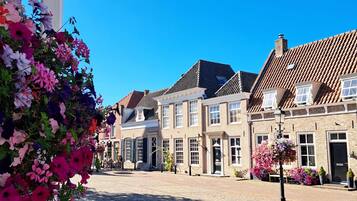 A traditional European street with historic buildings, cobblestone pavement, and flower arrangements.