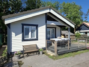 Een laag gebouw met een veranda en een bankje.