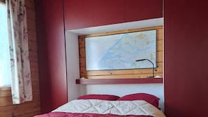 Ein Zimmer mit einem Bett, einer Wandkarte und Holzvertäfelung.