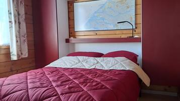 A room with a bed, a map on the wall, and wooden paneling.