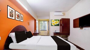 A hotel room with a bed, a desk, a telephone, a television, and artwork on the walls. - Super Townhouse Hubli Bus Terminal (Hubli-Dharwad)