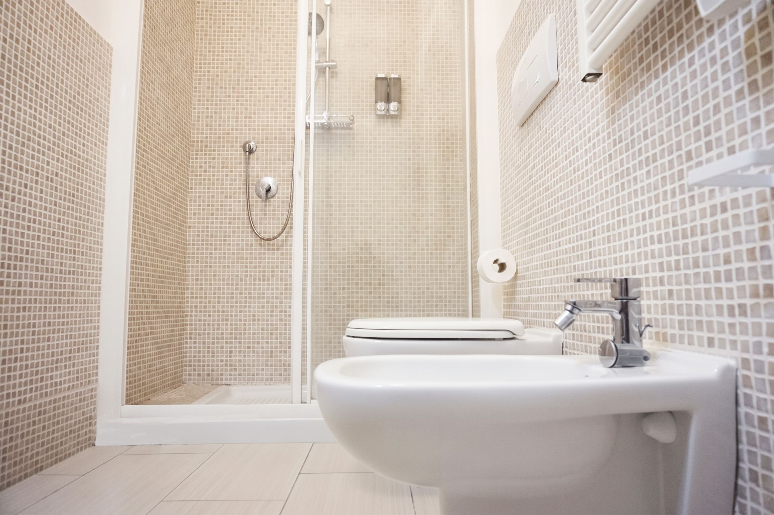 A bathroom with a shower, toilet, and sink.