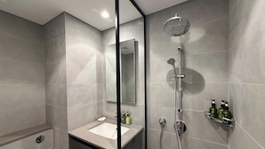 A modern bathroom with a shower, a sink, and a mirror. - Maison Sahab - Stylish Studio in Tiraz Building (Sharjah)
