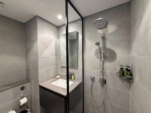 Un bagno moderno con doccia, lavabo e specchio.