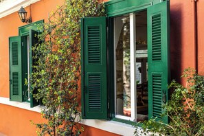 Ein Gebäude mit grünen Fensterläden und einer Kletterpflanze.
