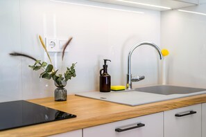 Eine moderne Küche mit einer Holz Arbeitsplatte, einem Spülbecken mit Armatur und einer Pflanzvase.
