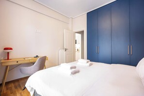 Ein Schlafzimmer mit einem Bett, einem Schreibtisch, einem Stuhl und einem Kleiderschrank.