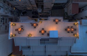 A rooftop terrace with multiple seating areas and tables, surrounded by buildings. - FiftySeven Athens - Acropolis View Terrace | 501 (Athina)